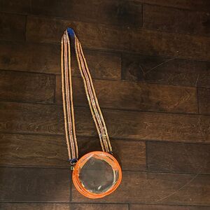 Clear Round Crossbody Bag with Orange Trim and Striped Strap